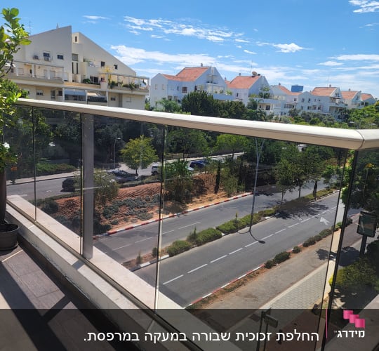 מעקה זכוכית במרפסת עם נוף לעיר